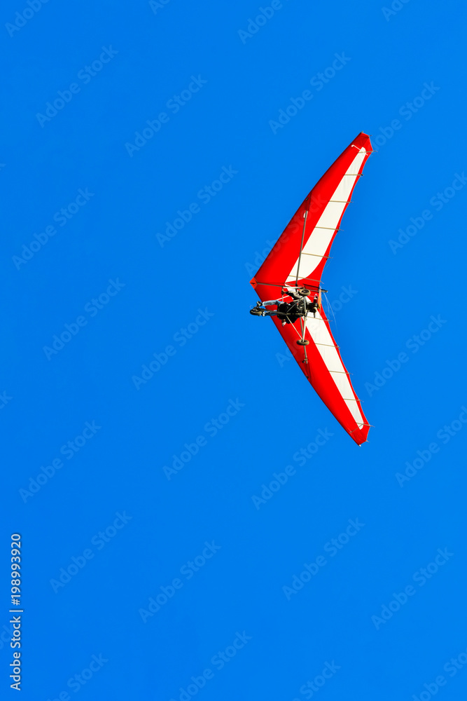 Naklejka premium The motorized hang glider in the blue sky