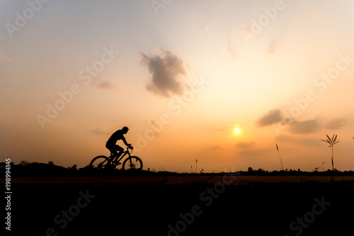 Silhouette of cyclist on beautiful sky ,Man ride bicycle on sunset background