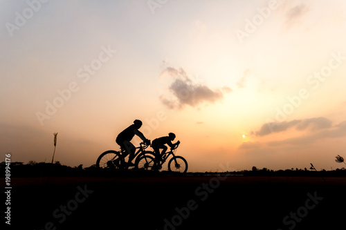 Silhouette of cyclist on beautiful sky ,Man ride bicycle on sunset background