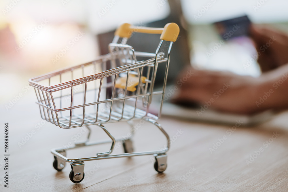credit card and cart or trolley on wood - Online payment concept