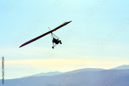 The motorized hang glider in the blue sky