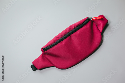 Waist bag of banana of red colour on a white background isolation photo