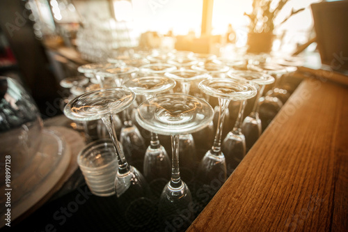 Empty inverted glasses on a table  in a restaurant. Toned