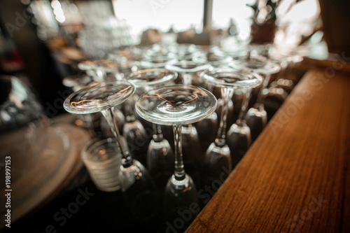 Fototapeta Naklejka Na Ścianę i Meble -  Empty inverted glasses on a table  in a restaurant. Toned
