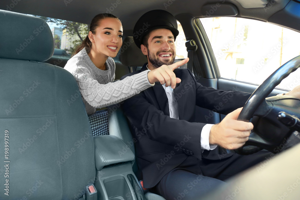 Young female passenger showing taxi driver the way Young female passenger showing taxi driver the way