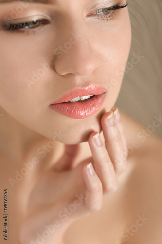 Young woman applying cream onto her skin  closeup