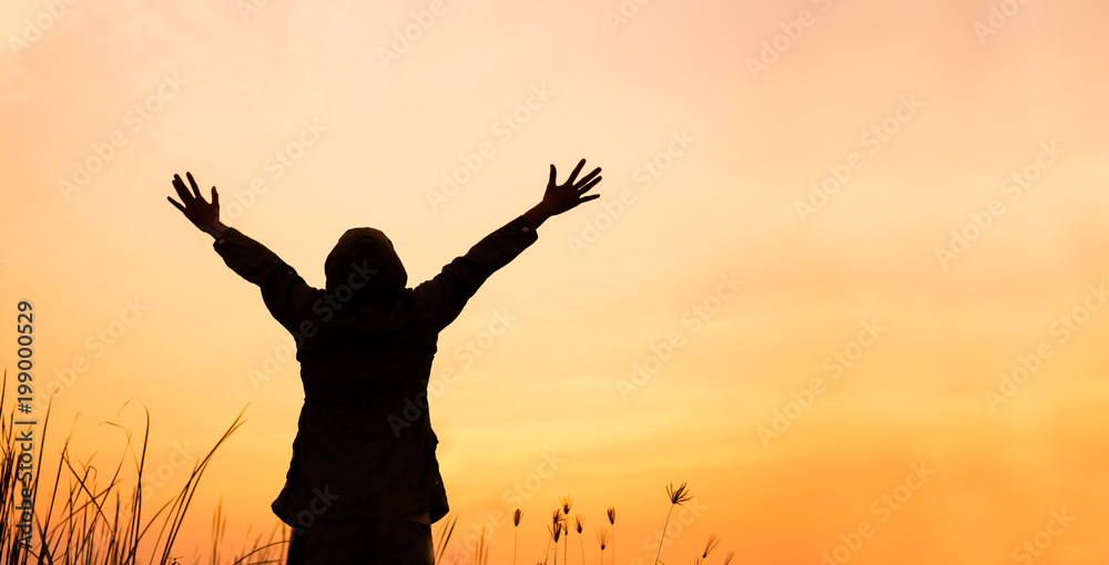 Asian woman enjoying nature and freedom , Women are lifting their hands up in the sky at sunset