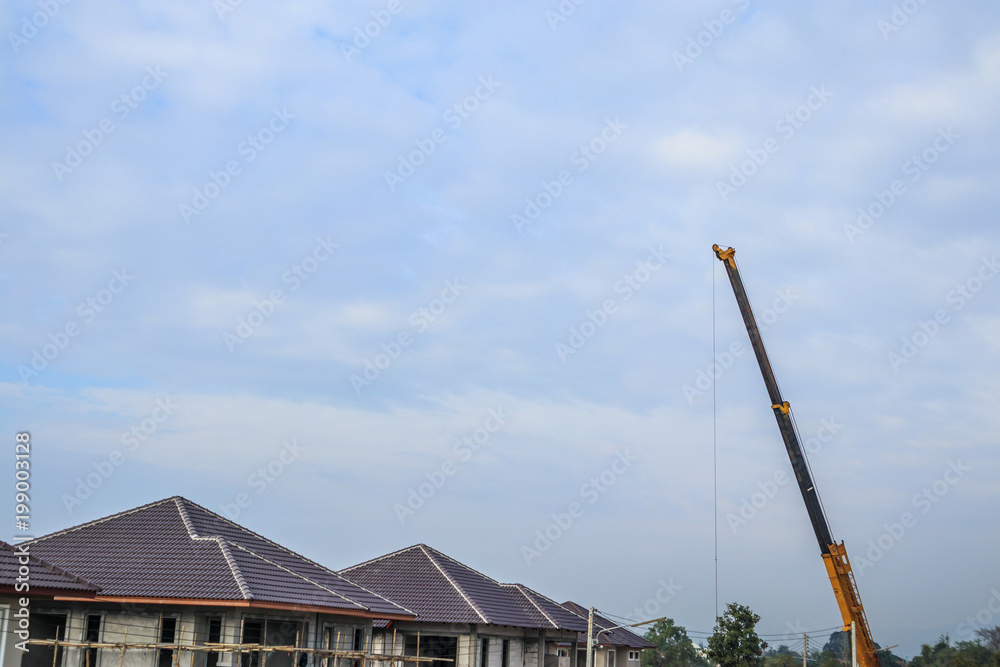yellow telescopic arms of mobile construction crane truck at house construction site yellow telescopic arms of mobile construction crane truck at house construction site