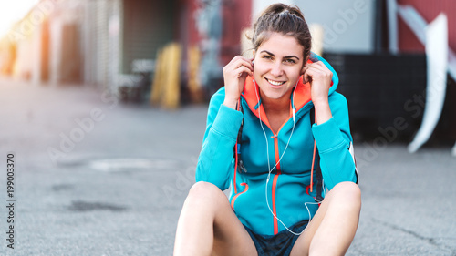 Woman listening music after street workout  city industrial area
