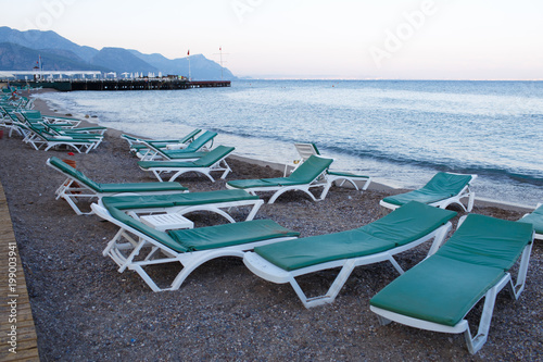 view from the pier to the beach with sun beds