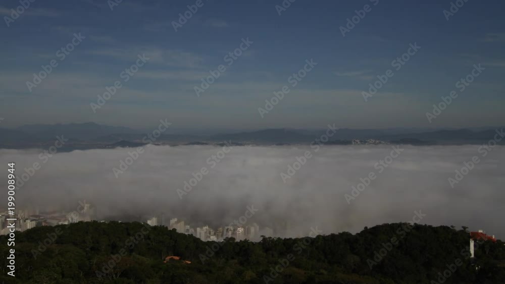 Time lapse - Fog over the city. Slowly dissolving in the morning and revealing the buildings bellow. Mystical moment. Florianópolis, Santa Catarina / Brazil Time lapse - Fog over the city. Slowly dissolving in the morning and revealing the buildings bellow. Mystical moment. Florianópolis, Santa Catarina / Brazil