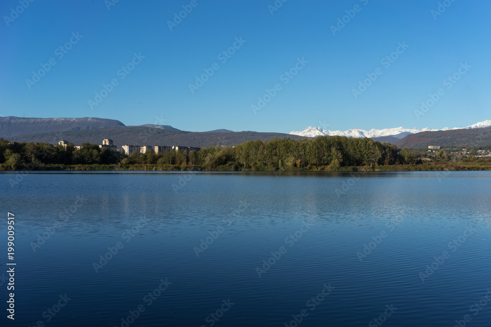 Landscape with a beautiful lake surrounded by houses and vegetation.