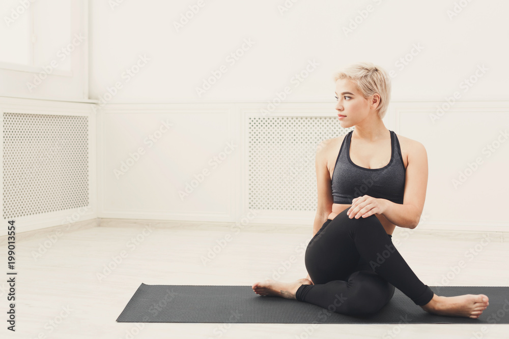 Woman training yoga in twisting sage pose. Woman training yoga in twisting sage pose.