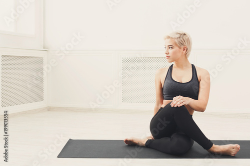 Fototapeta Naklejka Na Ścianę i Meble -  Woman training yoga in twisting sage pose.