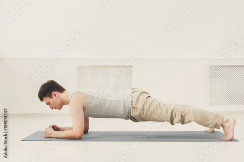 Fitness man training plank indoors