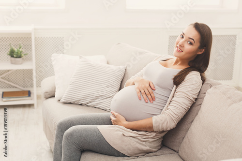 Smiling pregnant woman dreaming about child