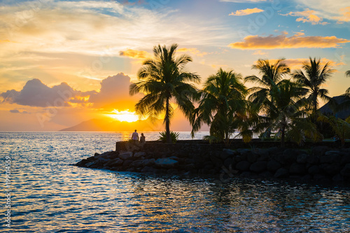 Silhouette of palm trees and sunset in Tahiti. 