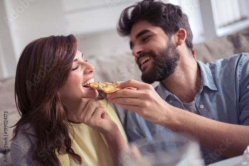 Couple eating pizza at home