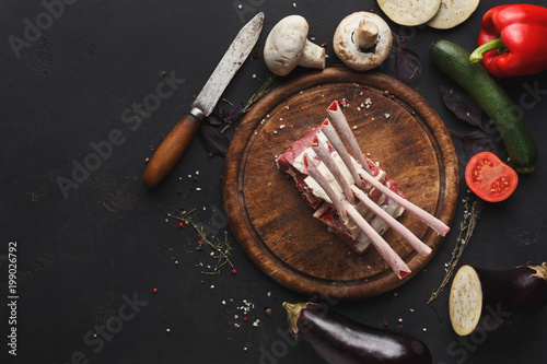 Raw rack of lamb on wooden board top view