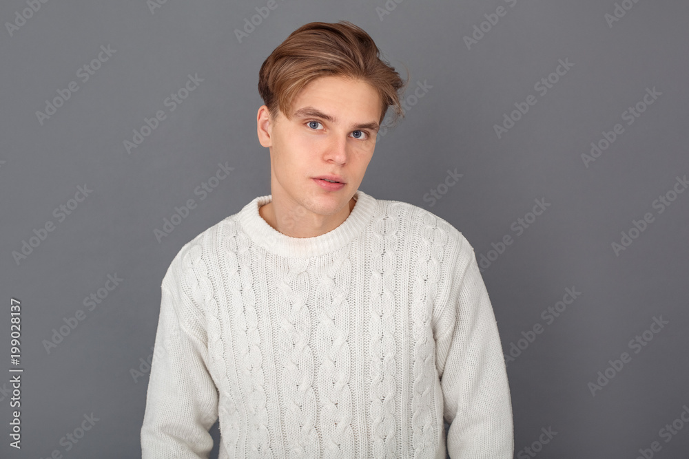Young man wearing sweater studio isolated on grey dreaming close-up Young man wearing sweater studio isolated on grey dreaming close-up