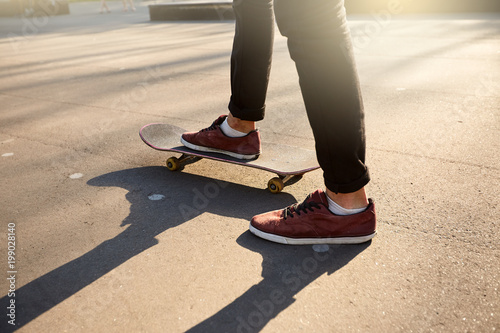 Close-up of skateboarders feet while skating in skate park. Man riding on skateboard. Isolated view, low angle shot.