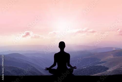 Yoga silhouette on the mountain in sunrays