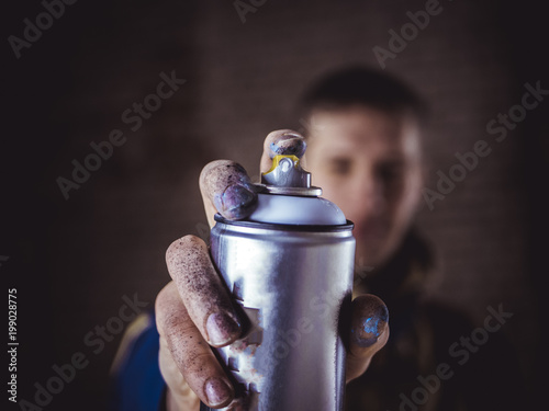 Fotografie street art artist holding spray paint can in the hand close up