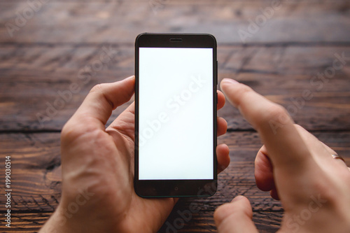 Mockup of blank screen of smartphone, male hand holding smartphone with template screen with area for your logo or design