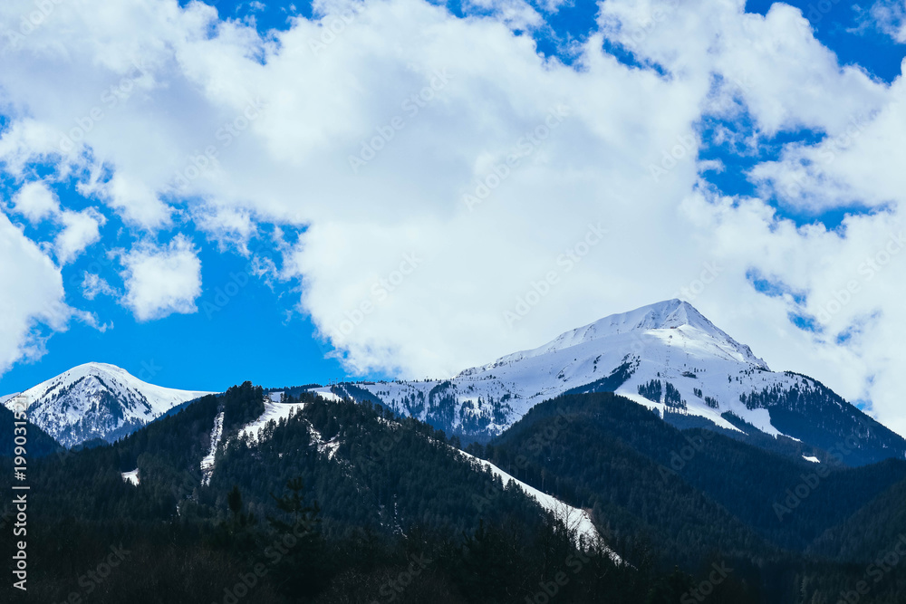 Mountain snow peak, beautiful natural winter backdrop. Ice top of the hill, blue sky background. Alpine landscape.