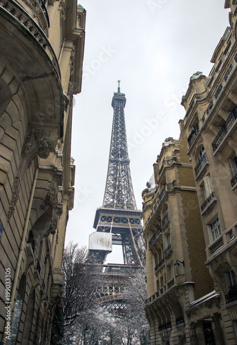 Paris, France - 8 February 2018 : view of the Eiffel Tower  under the snow between haussmanian buildings photo