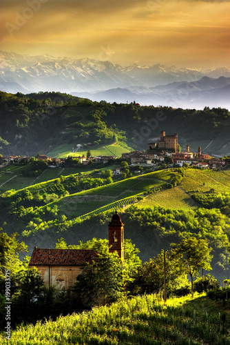 View of Serralunga d Alba with the sun that draws the ripples of the hills. We are in the wine producing area of Barolo. UNESCO World Heritage Site.