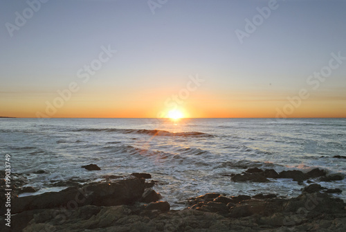 Sun Rising in the middle of a rocky sea at Punta del Este, Uruguay