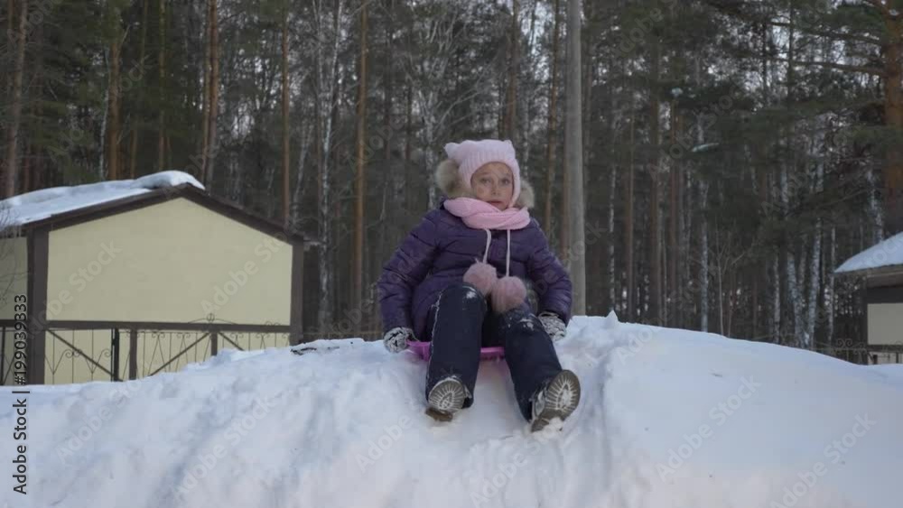 Little girl having fun on sledge on snowy hill Little girl having fun on sledge on snowy hill