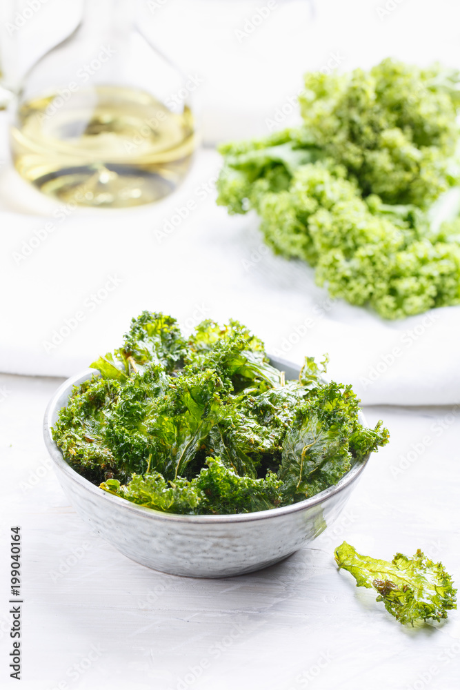 Kale chips in bowl. Crispy green kale chips dehydrated with salt, oil and vegan cheese. Healthy homemade vegan snack. Kale chips in bowl. Crispy green kale chips dehydrated with salt, oil and vegan cheese. Healthy homemade vegan snack.