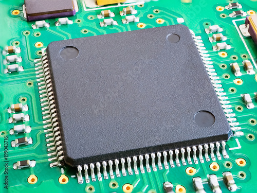 Close-up of electronic circuit board PCB with components: microchip, processor, integrated circuits, capacitors, resistances and electronic connections are noted. High-quality macro photography. photo