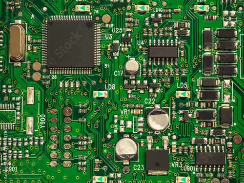 Close-up of electronic circuit board PCB with components: microchip, processor, integrated circuits, capacitors, resistances and electronic connections are noted. High-quality macro photography. photo