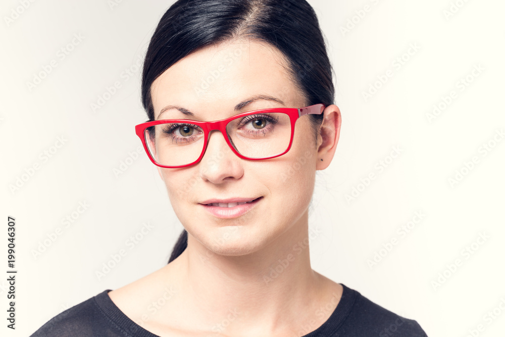 Portrait of a young woman with black hair and red glasses. Portrait of a young woman with black hair and red glasses.