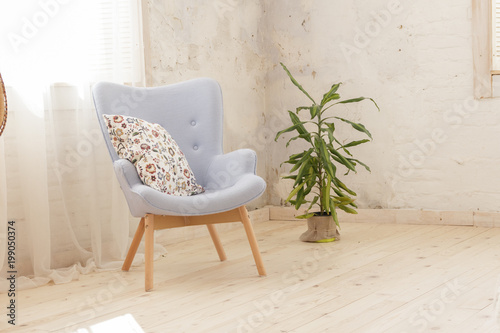 Modern blue armchair in a room with white curtains