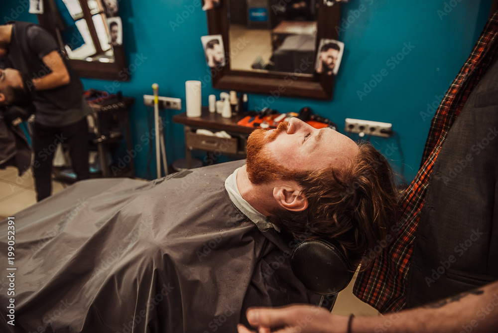 Professional Master hairdresser cuts client beard. Professional Master hairdresser cuts client beard.