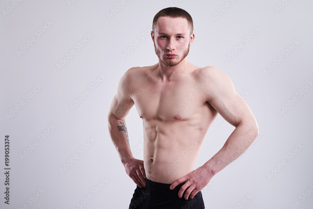 serious muscular man shoing his body