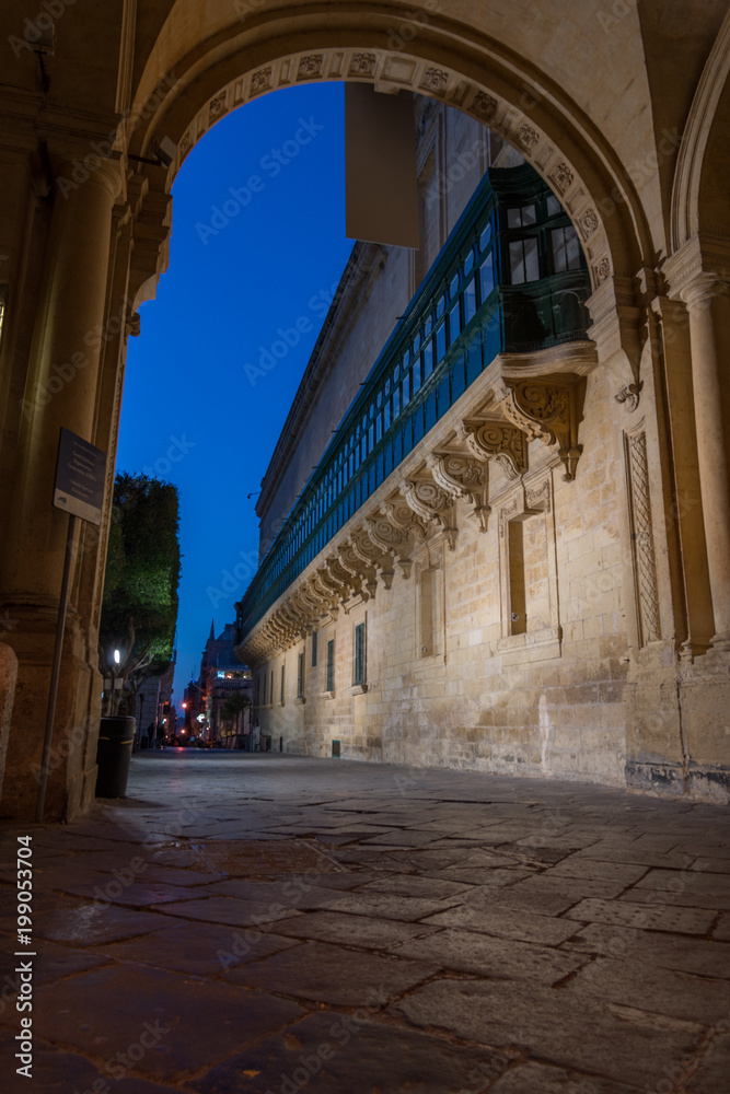 Vista da un porticato sulla città di La Valletta al calar della sera, Malta