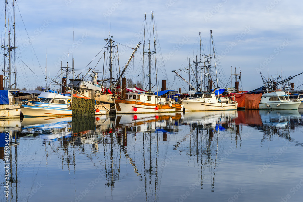 Fishing boats on the dock and their reflection