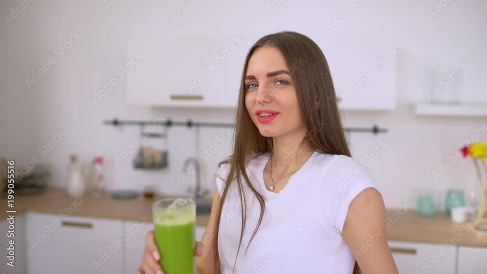 Happy young woman drinking fresh green juice enjoying detox cleanse. broccoli vegetable juice. 4 k Healthy eating, vegetarian food, weight loss and people concept. Vegetable detox cleanse smoothie Happy young woman drinking fresh green juice enjoying detox cleanse. broccoli vegetable juice. 4 k Healthy eating, vegetarian food, weight loss and people concept. Vegetable detox cleanse smoothie
