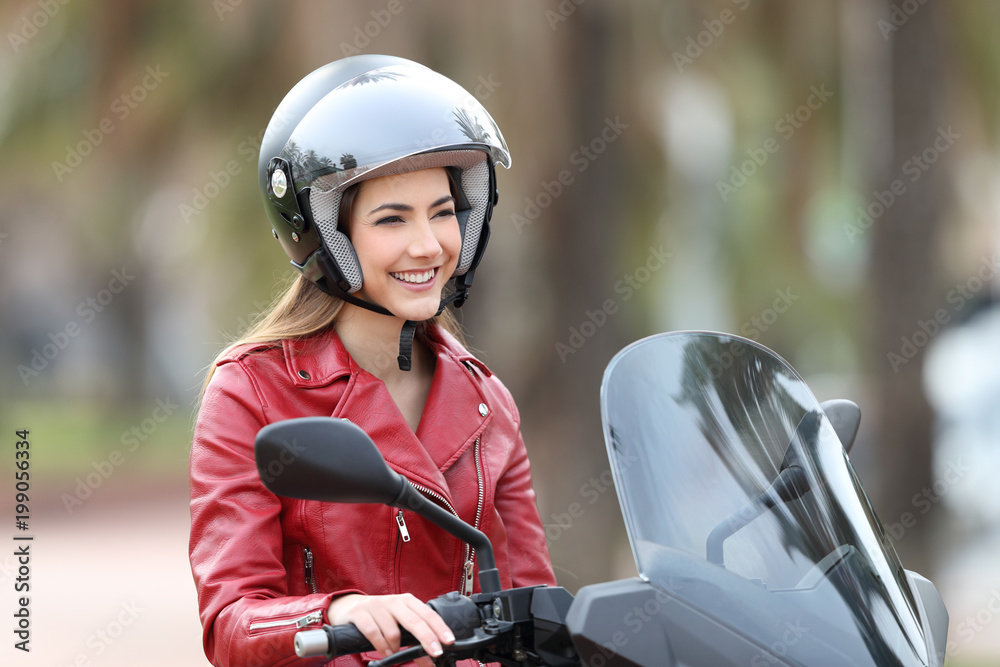 Happy biker on a motorbike looking away Happy biker on a motorbike looking away