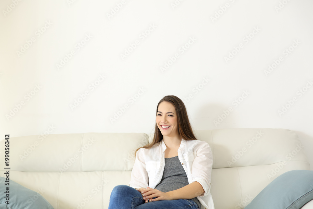 Homeowner sitting on a couch looking at camera Homeowner sitting on a couch looking at camera