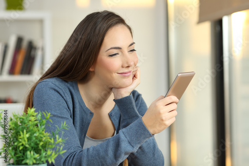 Relaxed girl checking a smart phone at home