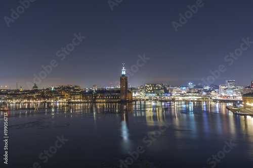 Stockholms Stadshus Tre kronor fotat en klar natt med Stockholms city i bakgrunden till höger photo