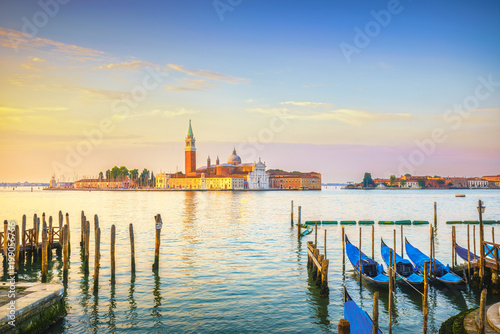 Venice lagoon, San Giorgio church, gondolas and poles. Italy