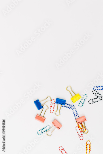 Fototapeta Naklejka Na Ścianę i Meble -  Top view of office accessories, paper clips, on white background with space for your text or photo