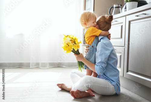 happy mother's day! baby son gives flowersfor  mother on holiday